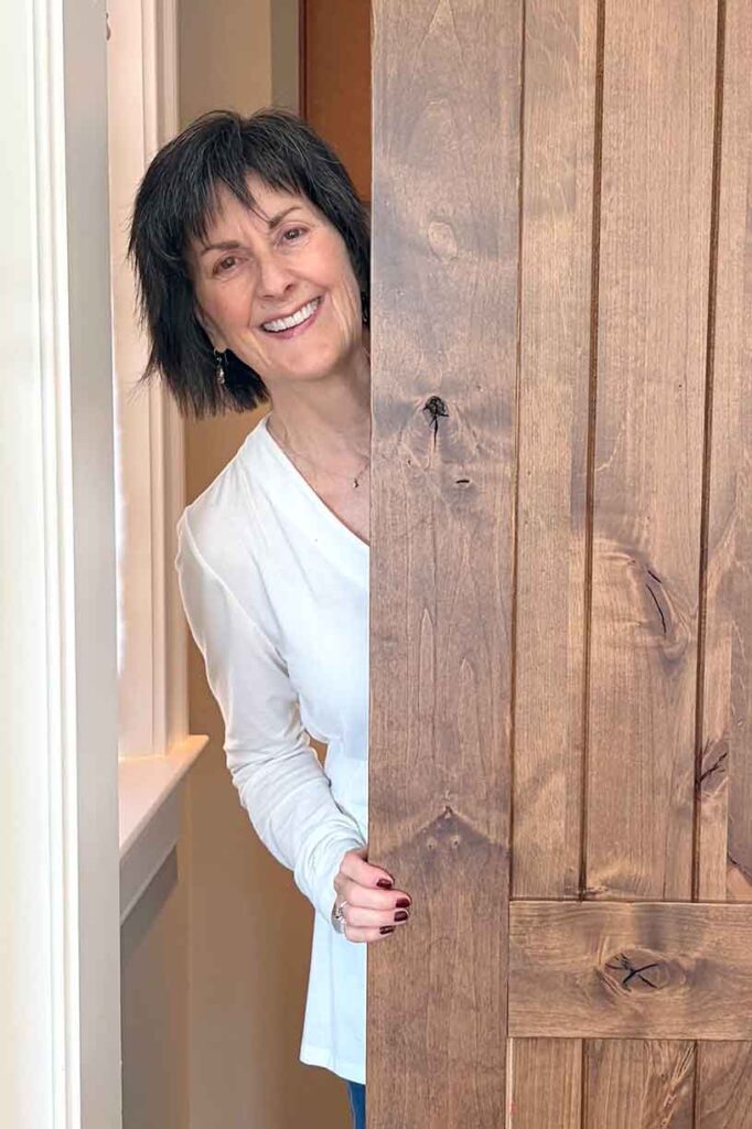 Portrait of Dawn Kacey standing in a doorway.